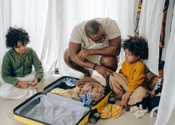 https://www.pexels.com/photo/african-american-father-with-kids-sitting-near-suitcase-4546014/